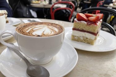 a cup of coffee and a piece of cake on a table